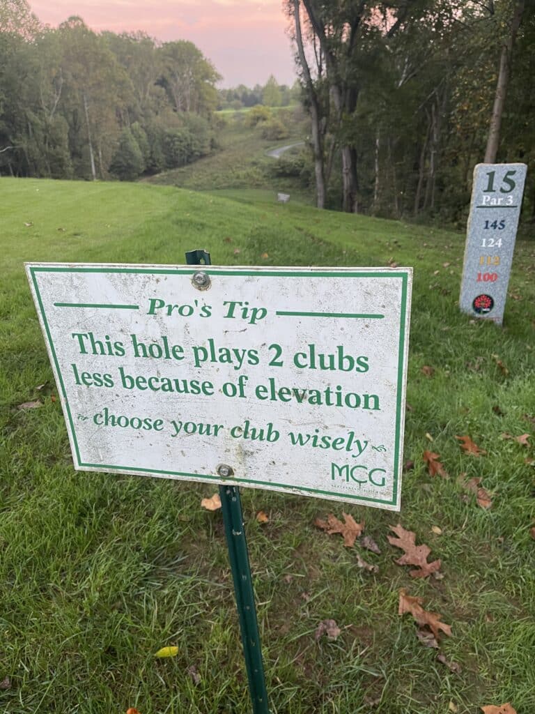 Little Bennett Golf Tee Shot Warning a Golf Course Tee in Mt Airy Md Features a Sign This Hole Plays 2 Clubs Less Because of Elevationchoose Your Club Wisely to the Right a Stone Marker Notes Hole 15 Par 3 with Distances Listed Trees and Fairway Stretch into the Background
