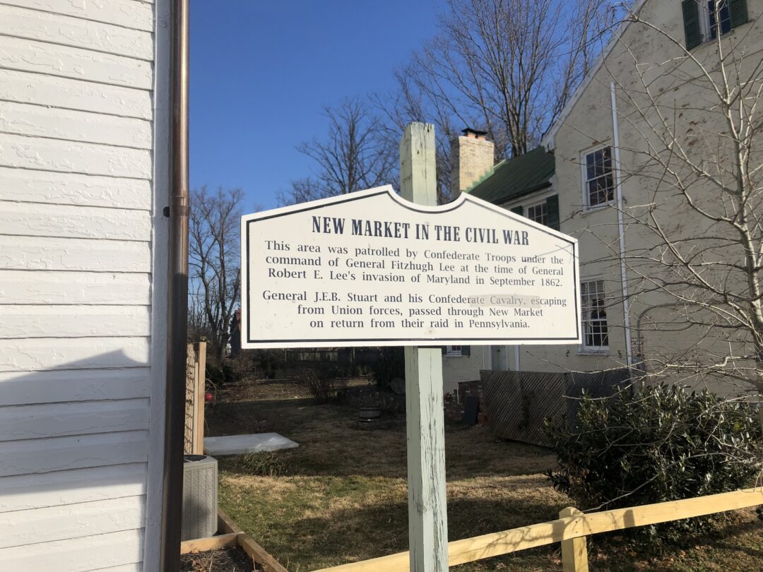 New Market in the Civil War Marker a White Historical Marker in New Market Md Reads New Market in the Civil War This Area Was Patrolled by Confederate Troops Under General Fitzhugh Lee During General Robert E Lees 1862 Maryland Invasion a House and Bare Trees Stand Behind the Sign