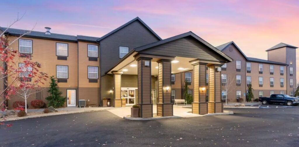 Best western bend oregon north hotel a Modern Three story Hotel with Tan and Brown Siding Stands Under a Pink and blue Sunset Skyan Inviting Choice for Those Seeking Where to Stay in Bend Oregon the Entrance Features a Covered Driveway and Landscaped Shrubs by the Parking Lot