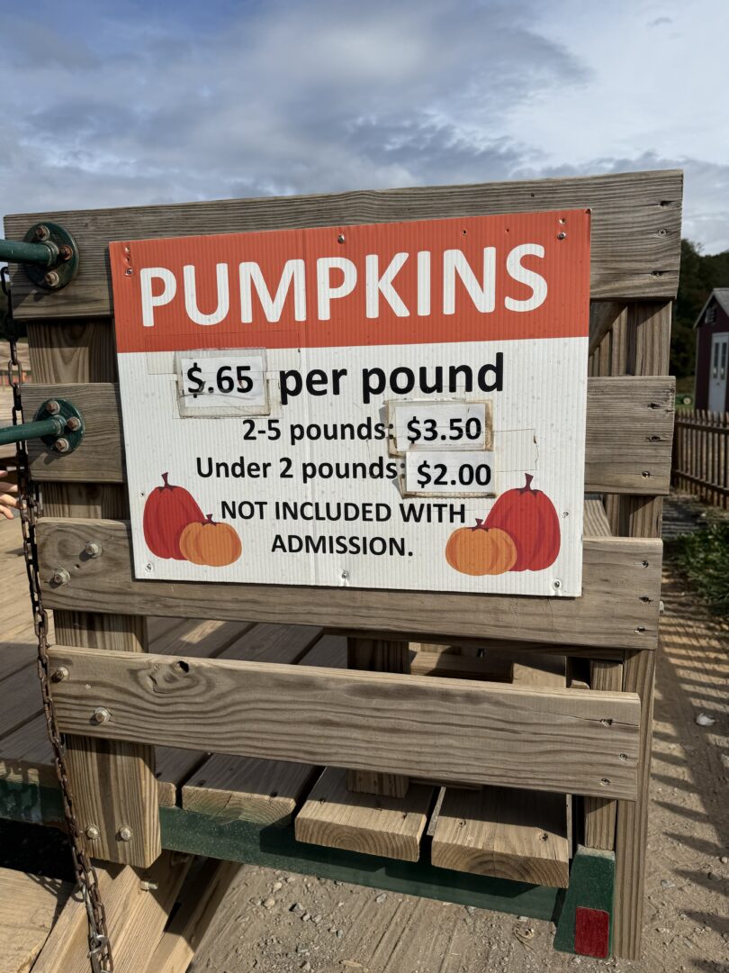 Pumpking sign gaver farm maryland a Wooden Sign at Gaver Farm Reads pumpkins 65¢ Per Pound 2 5 Pounds 0 Under 2 Pounds 0 Not Included with Admission the Sign with Red and Orange Pumpkins is Attached to a Wooden Fence Under a Blue Sky