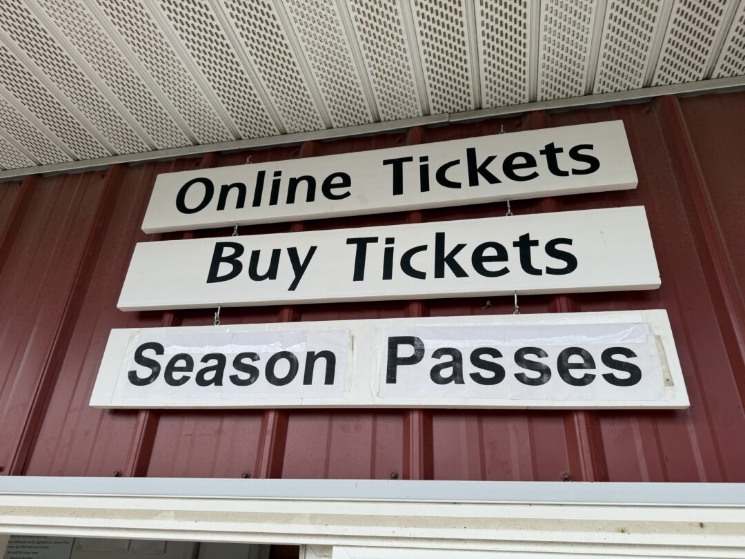 Ticket booth gaver farms Three White Rectangular Signs with Black Text Hang on a Red Metal Wall Under a Roof at Gaver Farm the Top Sign Reads Online Tickets the Middle Says Buy Tickets and the Bottom Reads Season Passes Guiding Visitors to Ticketing Options