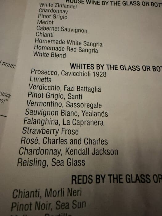 A close-up of a Cucina Massi Frederick MD restaurant menu lists various white wines by the glass or bottle, including Prosecco, Pinot Grigio, Sauvignon Blanc, Falanghina, Strawberry Frose, Chardonnay, and Riesling.