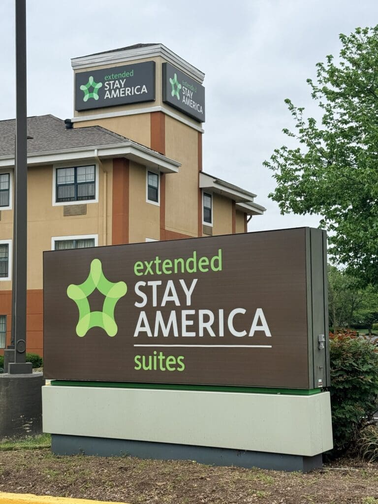 Extended stay americas frederick md 02 Exterior View of a Stay America Sign on a Beige Building with a Green Abstract Logo and the Words aposextended Stay Americaapos