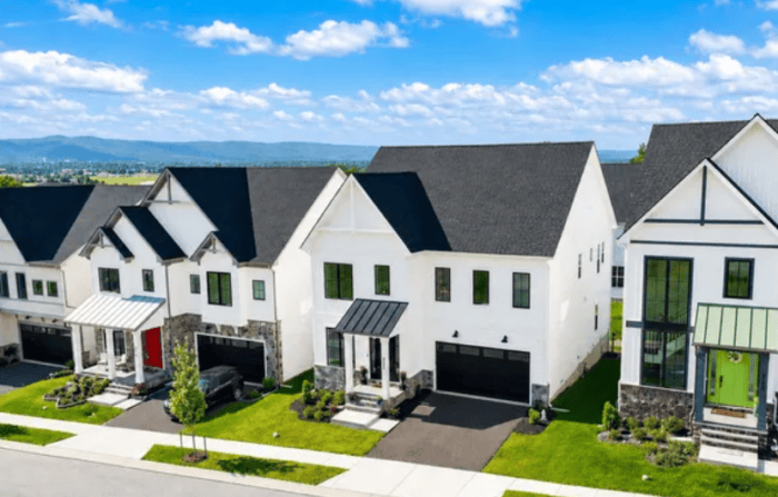 Row of Modern White Townhouses with Attached Garages on a Sunny Street