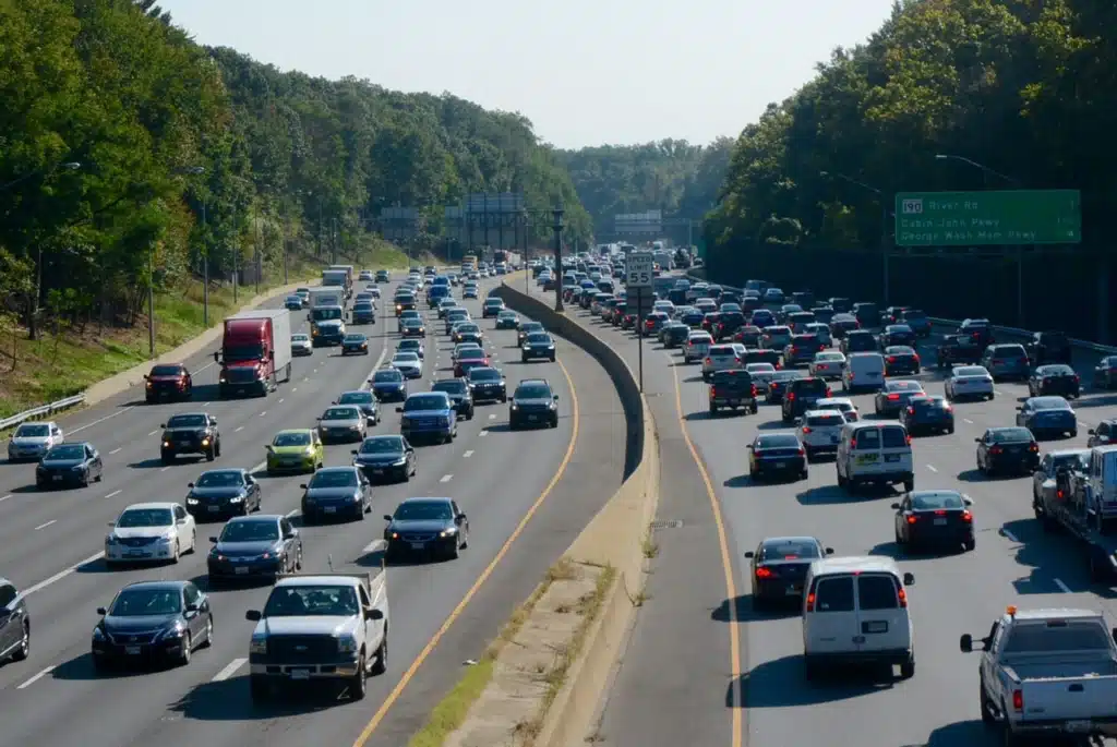 Heavy Freeway Traffic on a Divided Multi Lane Highway with Vehicles and Green Exit Signs Ahead